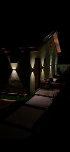 a building with lights on the side of it at night at Cherry hut in Ajloun