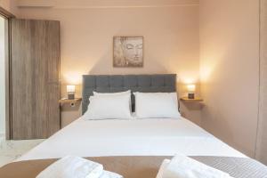 a bedroom with a large white bed with two lamps at Spyridoula House in Corfu