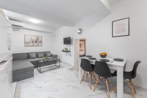 a living room with a table and chairs and a couch at Spyridoula House in Corfu
