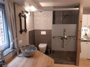 a bathroom with a bowl sink and a toilet at Pension Zur Mühle in Nettetal