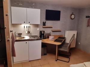 a kitchen with a table and a sink and a table and a tablektop at Pension Zur Mühle in Nettetal