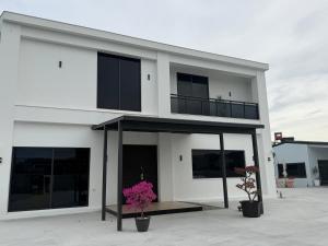 a white building with two potted plants in front of it at Six Children in Gongguan