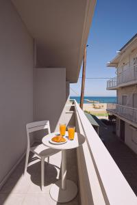 a balcony with a table and two glasses of orange juice at Azzurro in Nei Poroi