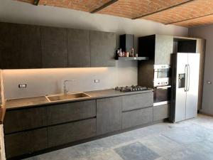 a kitchen with a sink and a refrigerator at Villa Corleone in Nizza Monferrato