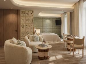 una camera da letto con un letto e un soggiorno di Hôtel de La Fontaine a Lourmarin