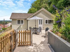 une maison avec une clôture en bois et une table avec un parasol dans l'établissement Bali - hi By Cliftonvalley Apartments, à Weston-super-Mare 2 autres photos