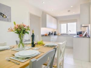 d'une cuisine avec une table avec des assiettes et des fleurs. dans l'établissement Bali - hi By Cliftonvalley Apartments, à Weston-super-Mare