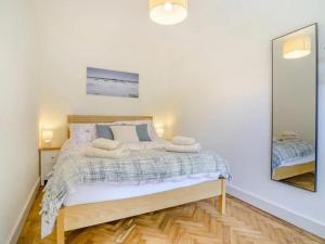 une chambre avec un lit et un miroir dans l'établissement Bali - hi By Cliftonvalley Apartments, à Weston-super-Mare