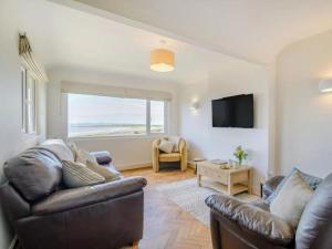 un salon avec un canapé en cuir et une télévision dans l'établissement Bali - hi By Cliftonvalley Apartments, à Weston-super-Mare