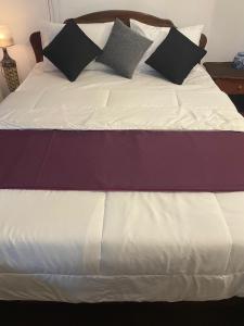 a bed with black and white pillows on it at Penthouse Bandarawela in Bandarawela