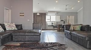 a living room with a couch and a table at Stripes & Sunsets Marloth Park in Marloth Park