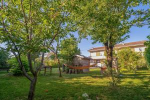 a hammock in the yard of a house at La casa in campagna in Cascina Grossa