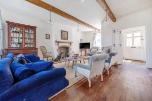 a living room with a blue couch and a table at Edinburgh House in Burnham Market