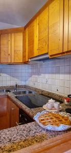 eine Küche mit Holzschränken und einer Arbeitsplatte in der Unterkunft La Casa della Nonna in San Vito di Cadore
