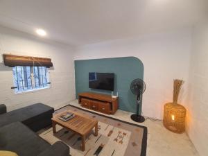 TV a/nebo společenská místnost v ubytování Tipima Guesthouse - Your Cozy Beach Escape