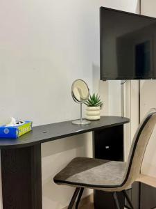 a desk with a chair with a mirror and a television at Room in new a renovated house with modern furniture in Esch-sur-Alzette