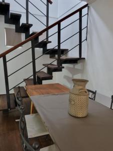 a table with a vase on it next to a staircase at Hornero House in San Antonio de Areco