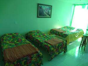 um quarto com duas camas e uma mesa e cadeiras em Flat Paraty Studio em Paraty