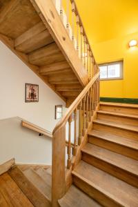un escalier en bois dans une maison aux murs jaunes dans l'établissement Chez Lilly - Neuf - Haut de Gamme - Tram - Proche centre-ville - Tout confort, à Strasbourg
