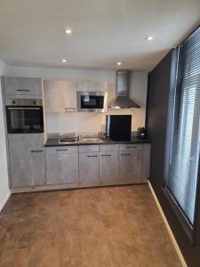 トゥルネーにあるUrban pause tournaiのステンレス製の器具と大きな窓のあるキッチン