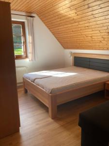 カルロヴァ・ストゥダーンカにあるApartmány u Reichlůの木製の天井と大きなベッドのある寝室