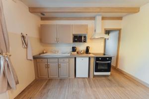 a small kitchen with a sink and a stove at Instants Précieux - Love Room in Arvert +5 photos