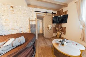 a room with a bed and a surfboard on a table at Instants Précieux - Love Room in Arvert