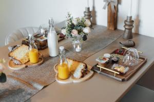 a table with a tray of bread and orange juice at Instants Précieux - Love Room in Arvert