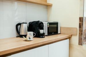 un four micro-ondes assis sur un comptoir avec deux tasses à café dans l'établissement Central Apartment Facing the Cathedral, à Chişinău