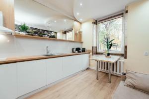 une cuisine avec des armoires blanches et une table dans l'établissement Central Apartment Facing the Cathedral, à Chişinău