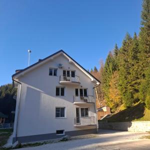 a white building with balconies on the side of it at Apartments Gozdni Raj Rogla in Oplotnica