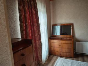 a room with a television on a dresser with a curtain at Zeyva Farm House in Zeyva