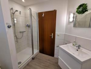 a bathroom with a shower and a sink and a shower backdoor at Ferienhaus Mehler - Heiligenhafen in Heiligenhafen