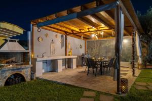 een buitenkeuken en een eethoek van een huis 's nachts bij Mika Villa in Afantou