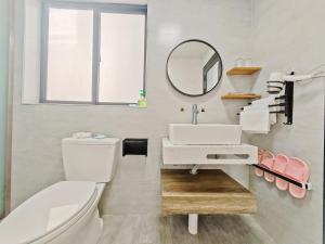 Un baño con lavabo, inodoro y espejo. en A&G Apartment, en Zhangjiajie 79 fotos más