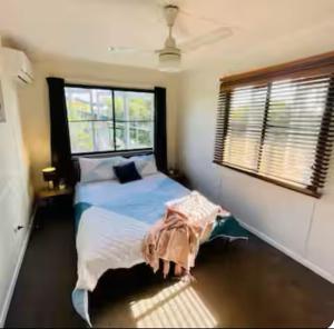 a bedroom with a bed and a window at Relax & Unwind, 5BR Home with Pool Near CBD in Garbutt Station