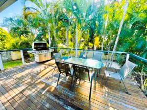 a patio with a table and chairs and a grill at Relax & Unwind, 5BR Home with Pool Near CBD in Garbutt Station