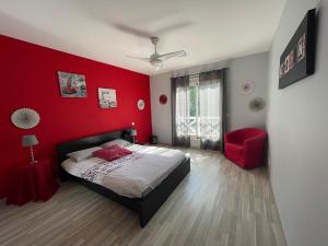a red bedroom with a bed and a red wall at Villa La Hispañola in Arès