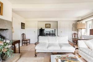 un salon avec un canapé blanc et une cheminée dans l'établissement Woodlea Cottage, à Moffat