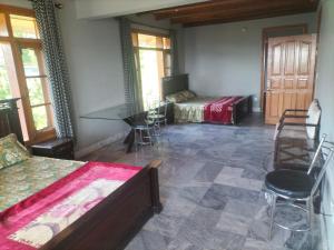 une chambre avec deux lits, une table et des chaises dans l'établissement Ad cottage, à Nathia Gali 2 autres photos