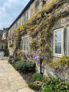 un bâtiment avec des fleurs violettes sur son côté dans l'établissement Woodlea Cottage, à Moffat