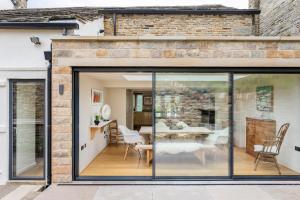 une extension vers une maison avec portes coulissantes en verre dans l'établissement Woodlea Cottage, à Moffat