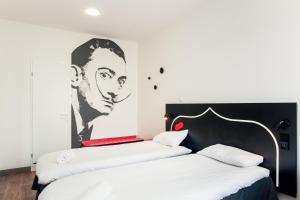 twee bedden in een kamer met een schilderij aan de muur bij St Christopher's Inn Paris - Gare du Nord in Parijs +37 foto's