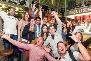 een groep mensen die met hun handen omhoog in een bar staan bij St Christopher's Inn Paris - Gare du Nord in Parijs