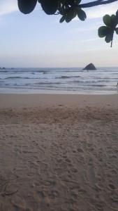 a beach with footprints in the sand and the ocean at ANGEL VILLA , Place with nature and care in Midigama West