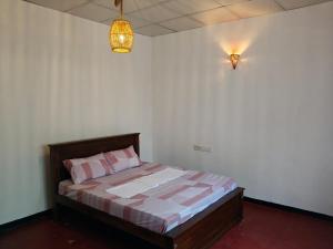 a bedroom with a bed with pink pillows and a light at ANGEL VILLA , Place with nature and care in Midigama West