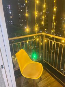 a yellow chair sitting on a balcony with lights at FAMILY ONLY -No unmarried couple allowed #2 in Thane