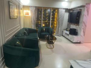 a living room with two green chairs and a television at FAMILY ONLY -No unmarried couple allowed #2 in Thane