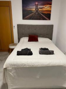 ein Schlafzimmer mit einem Bett mit zwei Handtüchern darauf in der Unterkunft Encantador ático con chimenea y piscina en Almería in Retamar