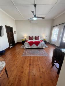 a bedroom with a bed with red pillows on it at Toni's Cottage in Graaff-Reinet